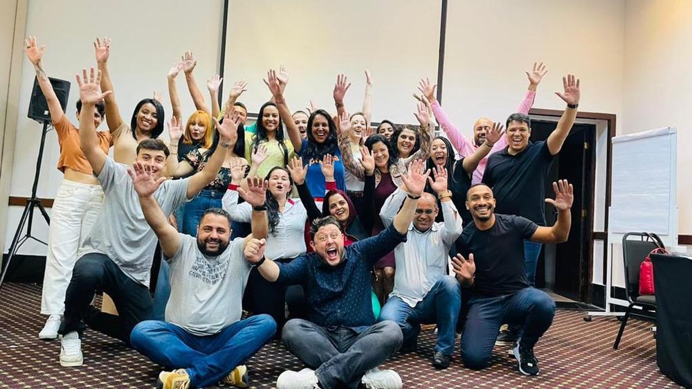 Equipe de varejo comemorando ao final de uma formação da Performance Varejo