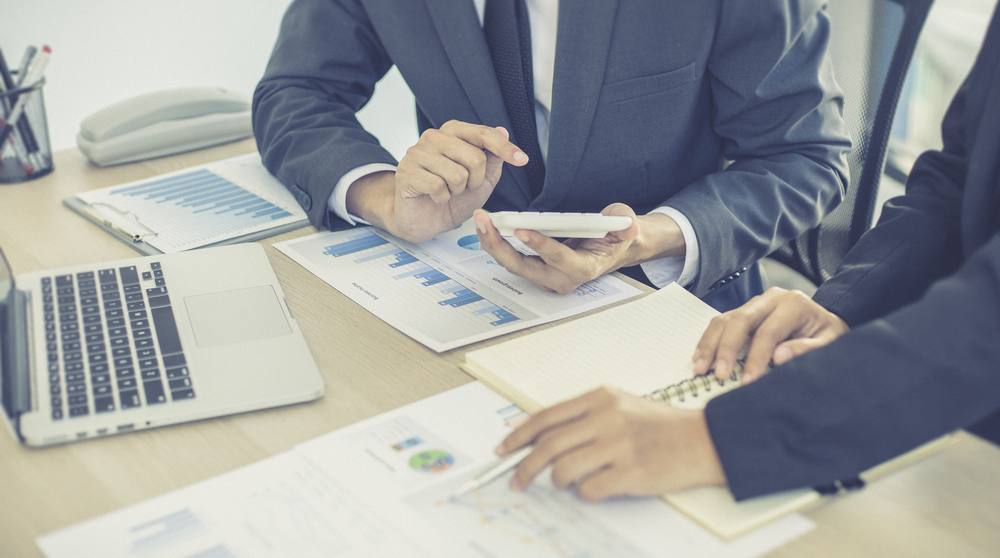 Profissionais analisando gráficos de desempenho sobre uma mesa