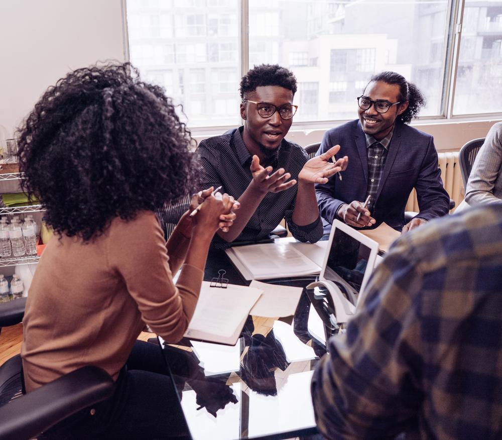Profissionais conversando em volta de uma mesa durante uma formação